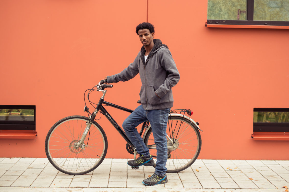 Adhanom zeigt stolz sein repariertes Fahrrad.