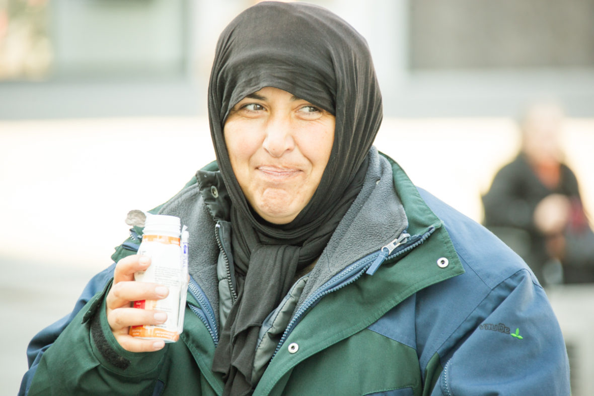 Eine obdachlose Frau trinkt ein Joghurtgetränk.
