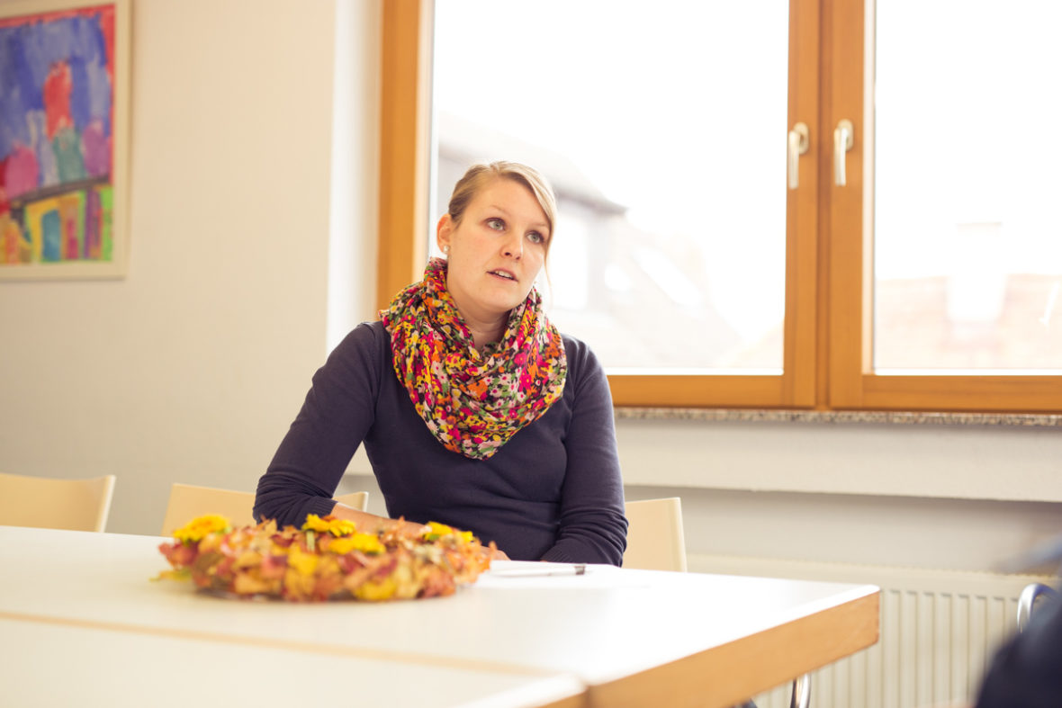 Gruppenleiterin Isabelle Forstner sitzt am Tisch in dem Raum, in dem die Gesprächsgruppe sich wöchentlich trifft.