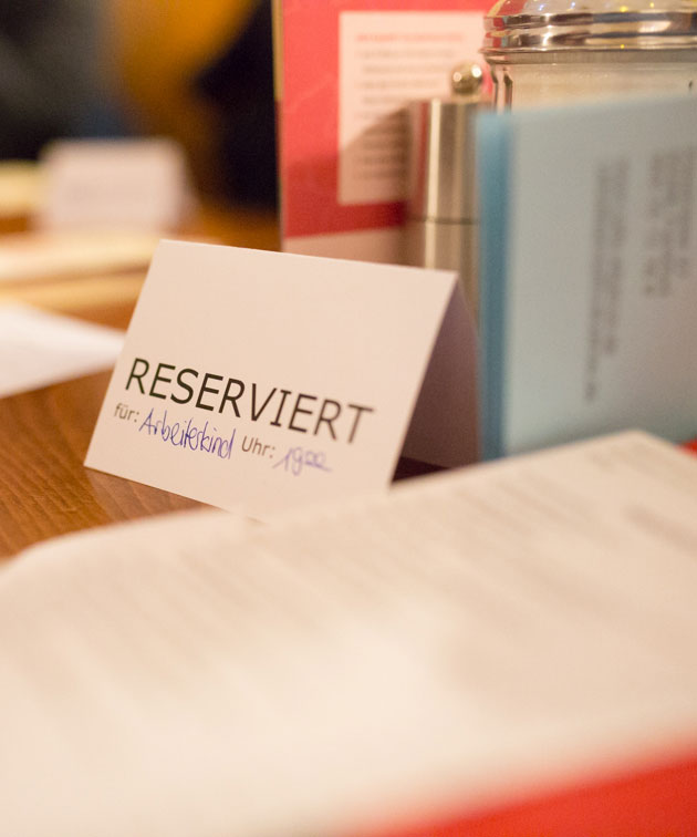 Ein Reserviert-Kärtchen auf einem Tisch, darauf steht: Arbeiterkind, 19 Uhr.