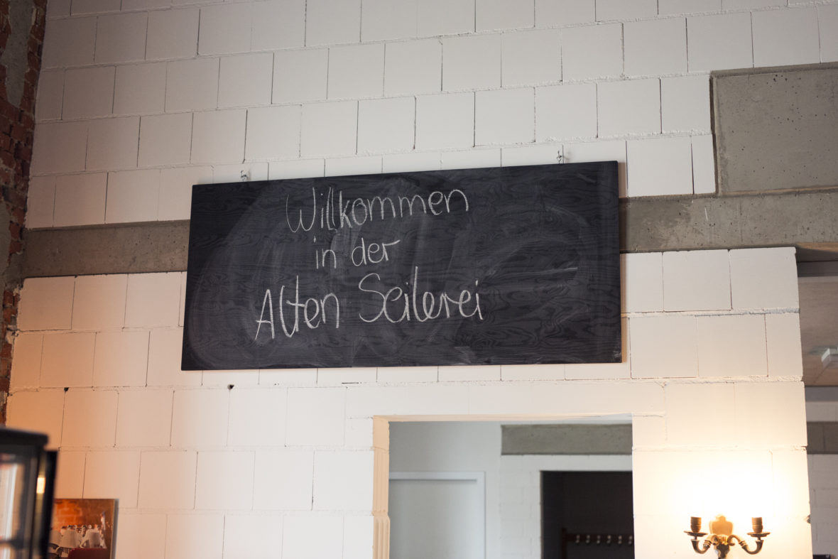 Tafel über dem Barbereich mit der handgeschriebenen Aufschrift "Willkommen in der alten Seilerei".