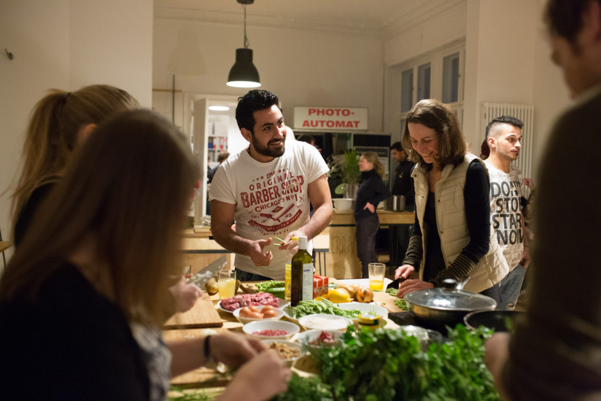 Ein Mann und eine Frau stehen an einem Tisch voller Zutaten und kochen.