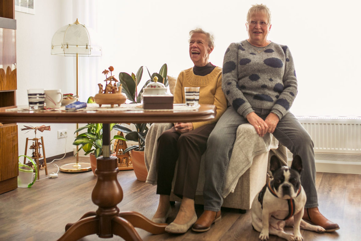 Eine Seniorin und ihre Tochter sitzen in ihrem Zimmer in einer Senioren-WG.