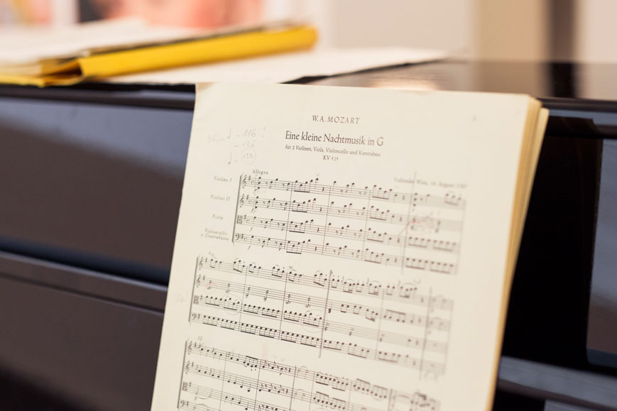 Notenblätter von Mozarts kleiner Nachtmusik in G liegen auf einem Klavier.