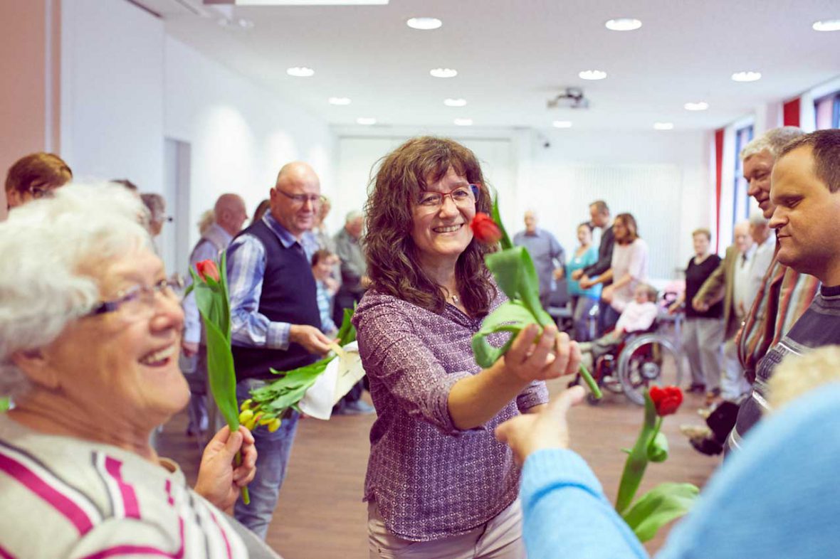 Tanzlehrerin Annelie überreicht jedem Teilnehmer eine Tulpe am Ende des Tanztees.
