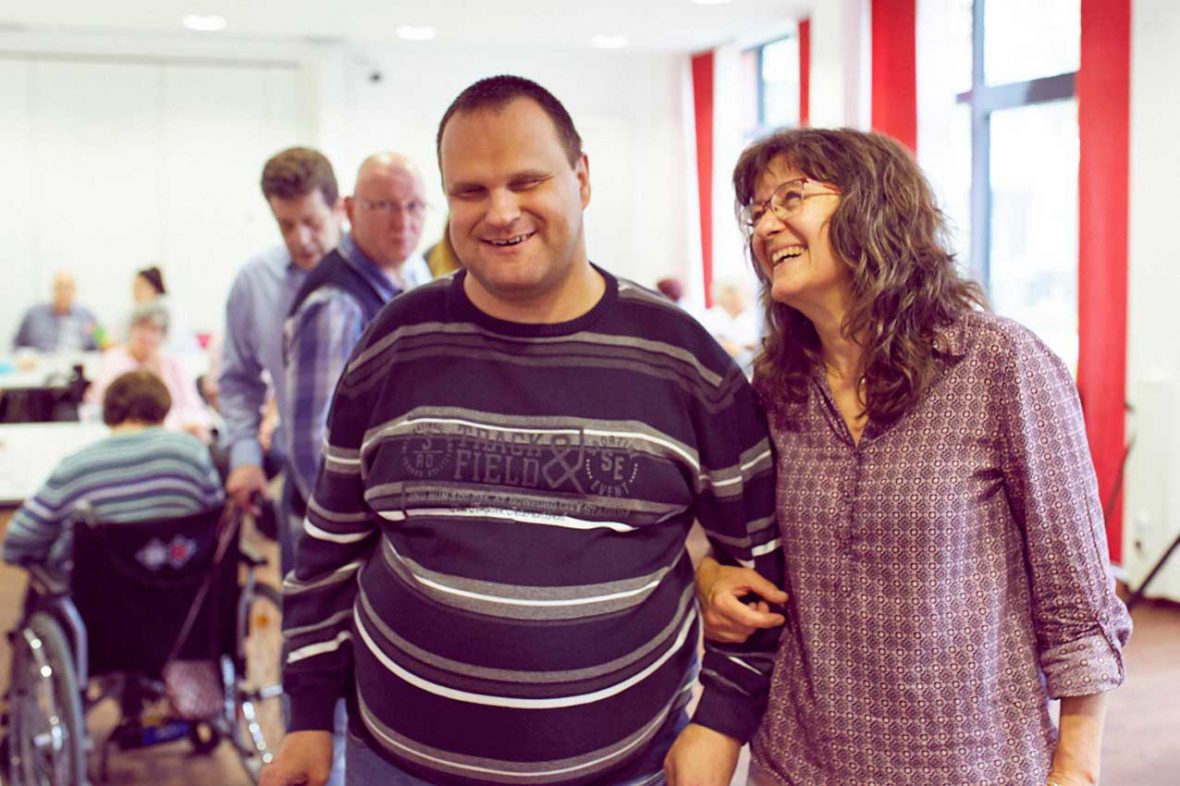 Tanztherapeutin Annelie mit Markus. Die beiden lachen fröhlich.