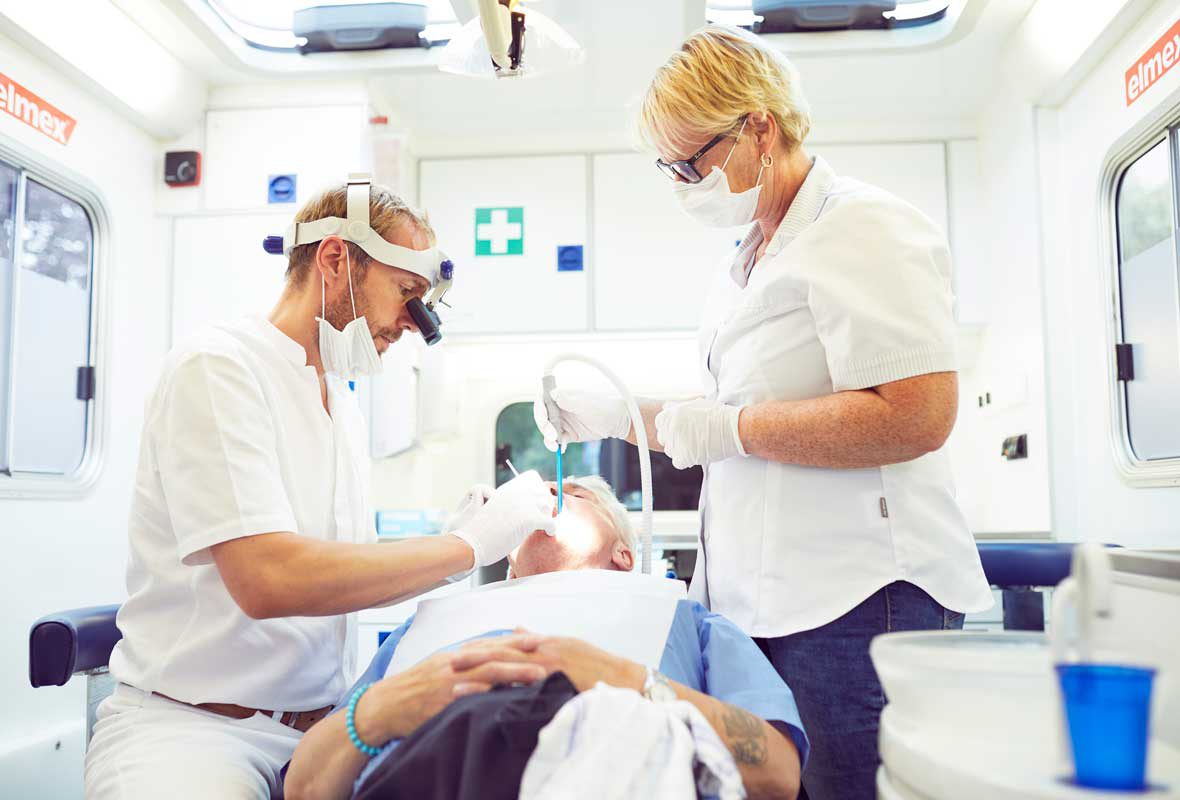 Dr. Uphoff und Anja Kleinschmidt behandeln einen Patienten im Zahnmobil der Caritas Hamburg