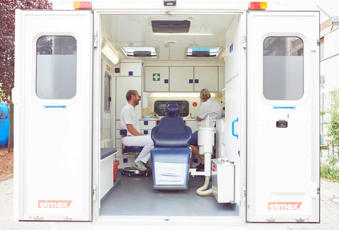 Ein Blick in das Zahnmobil der Caritas Hamburg: In der Mitte des umgebauten Krankenwagens steht ein blauer Behandlungsstuhl