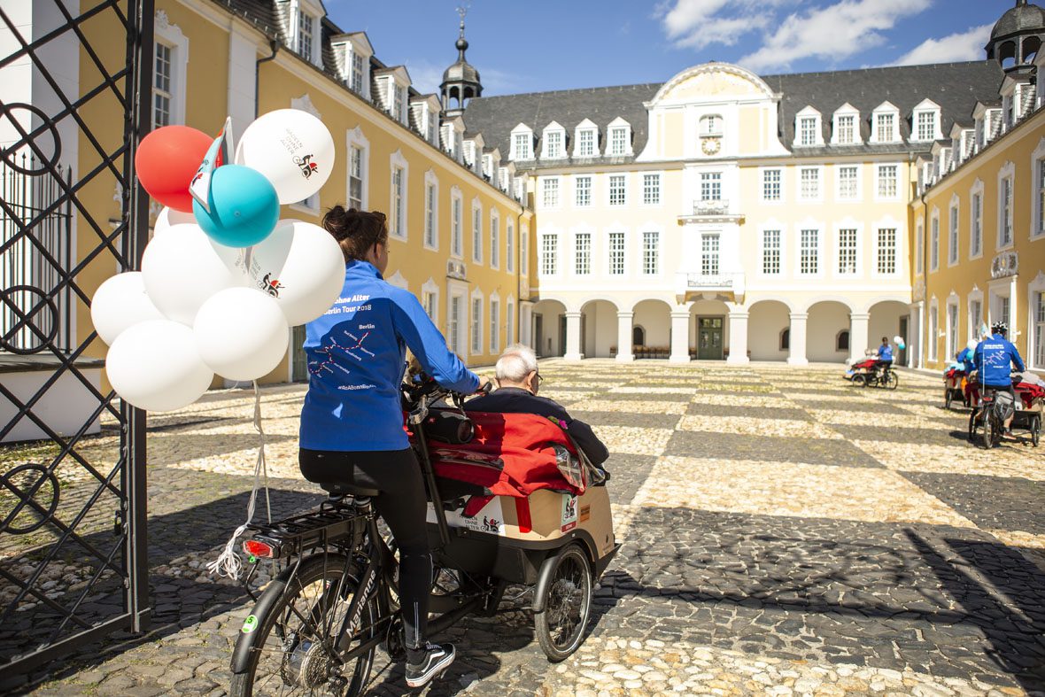 Vier Fahrradrikschas mit Faherer*innen und Passagieren fahren auf den Hof des Schloss Oranienstein in Diez .