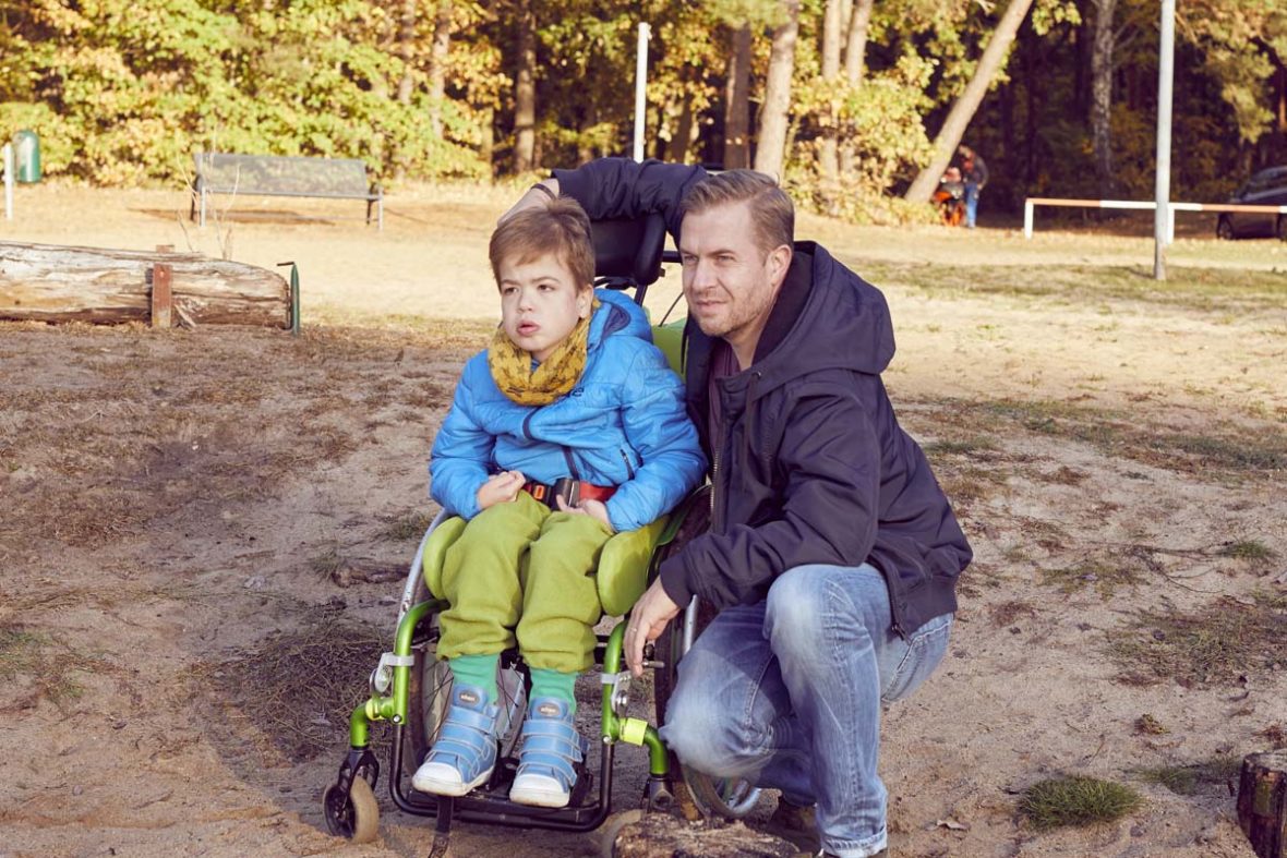 Daniel Burdach mit Sohn Filip, der Junge sitzt im Rollstuhl.