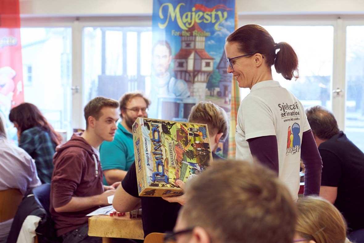 Petra Fuchs trägt ein Spiel durch das voll besetzte Spielecafé der Generationen.