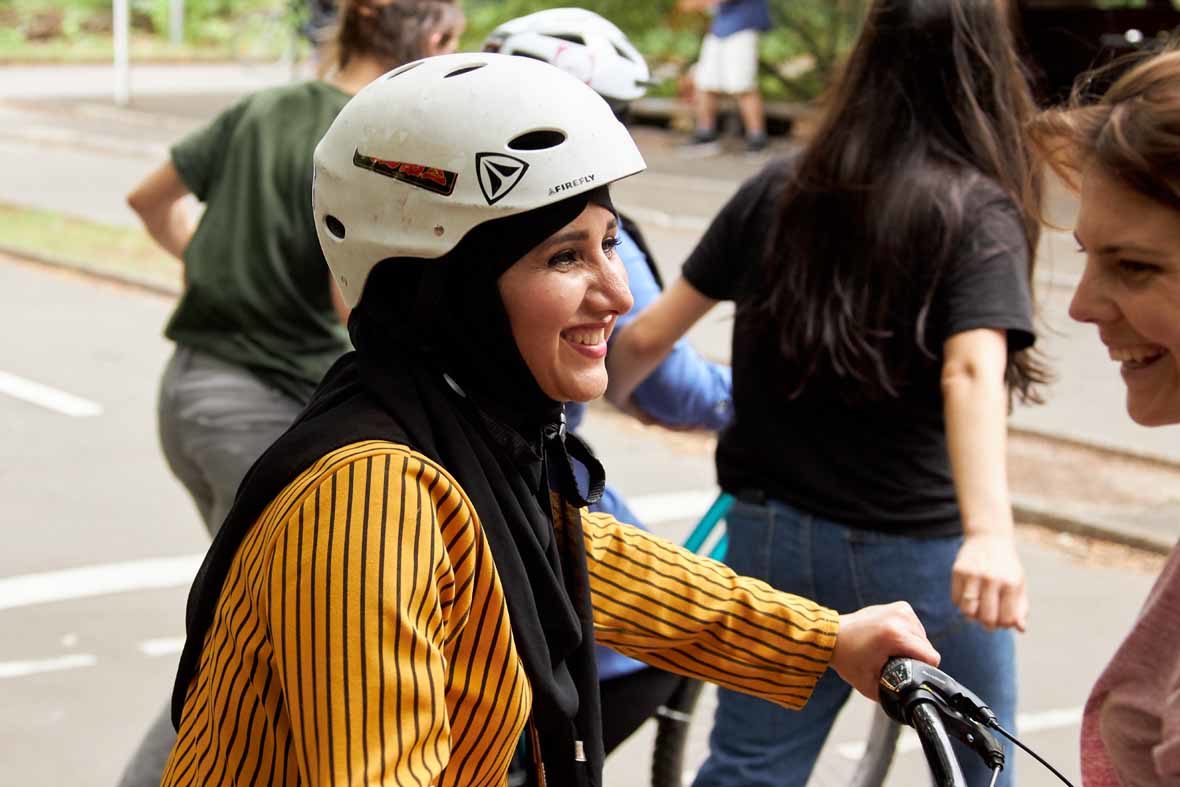 Foto: Eine junge Frau mit Fahrradhelm lächelt.