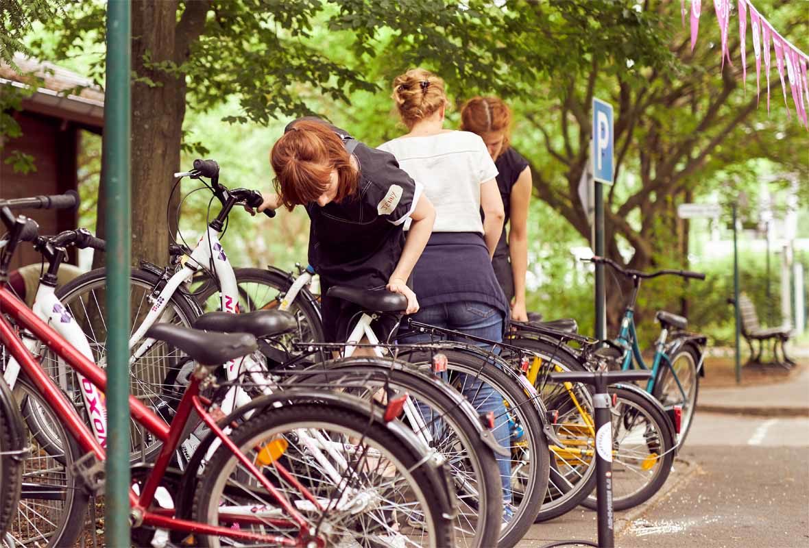 Foto: Eine junge Frau stellt Fahrräder an einen Sammelplatz