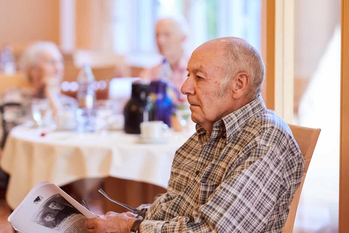 Foto: Ein älterer Mann hält einen Zettel in der Hand