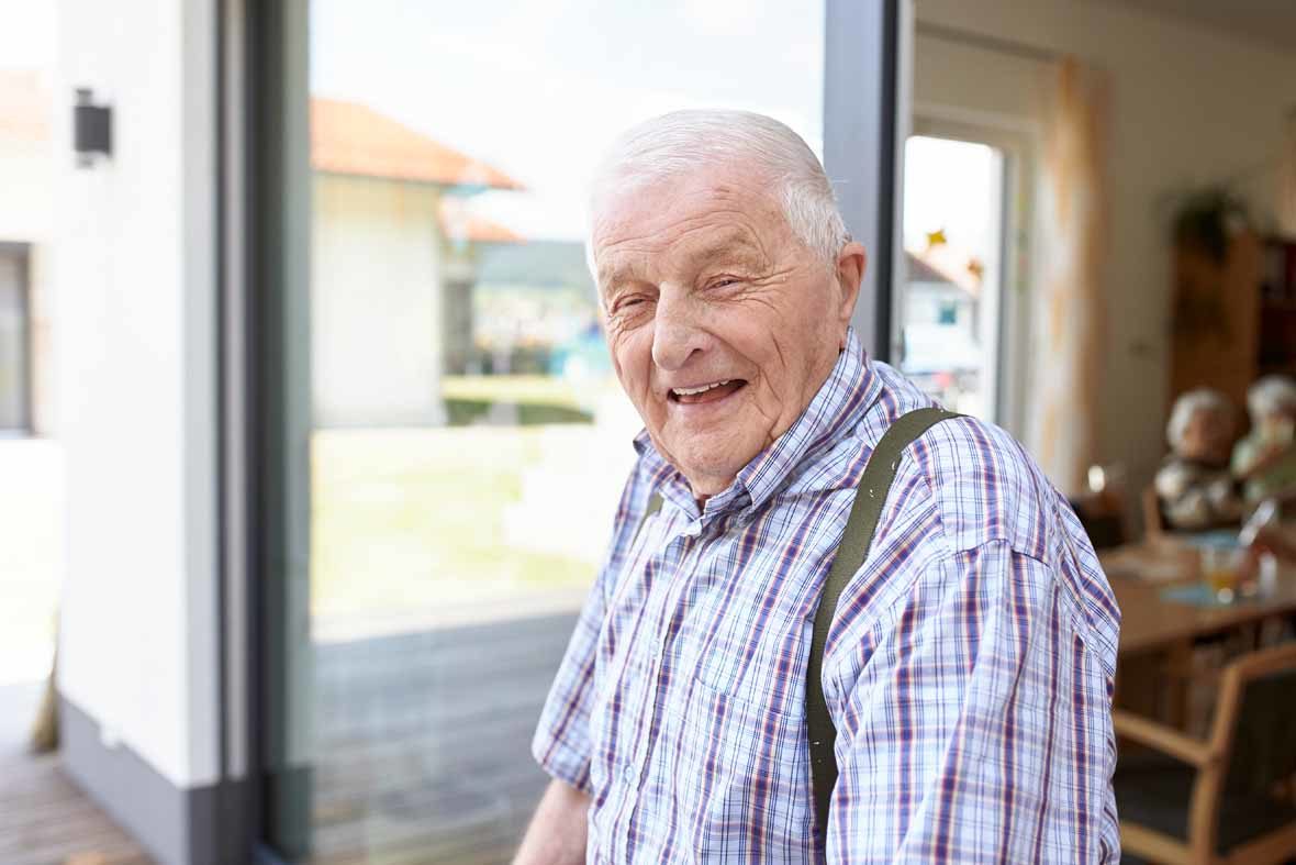 Foto: Ein alter Mann schaut in die Kamera und lacht