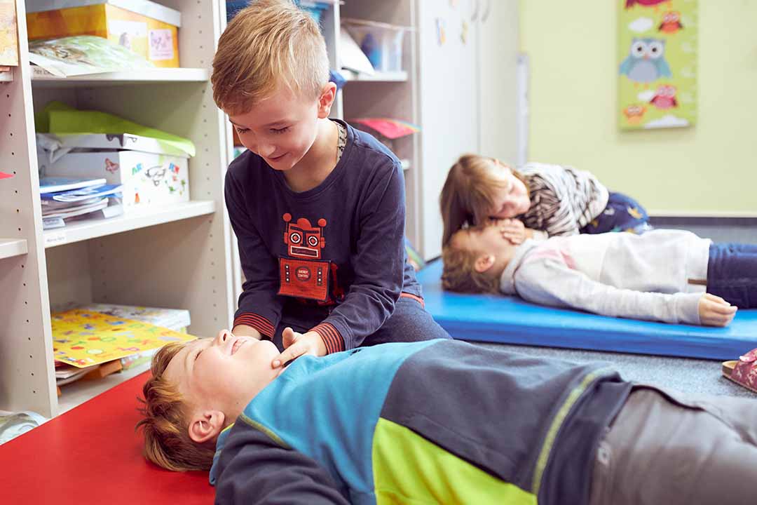 Ein Junge überprüft bei einem anderen Jungen die Atmung.