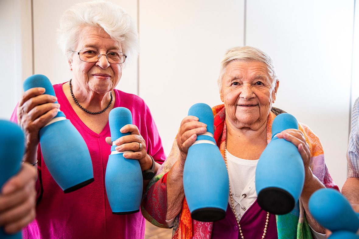 Zwei ältere Frauen halten Schaumstoffkegel in der Hand.