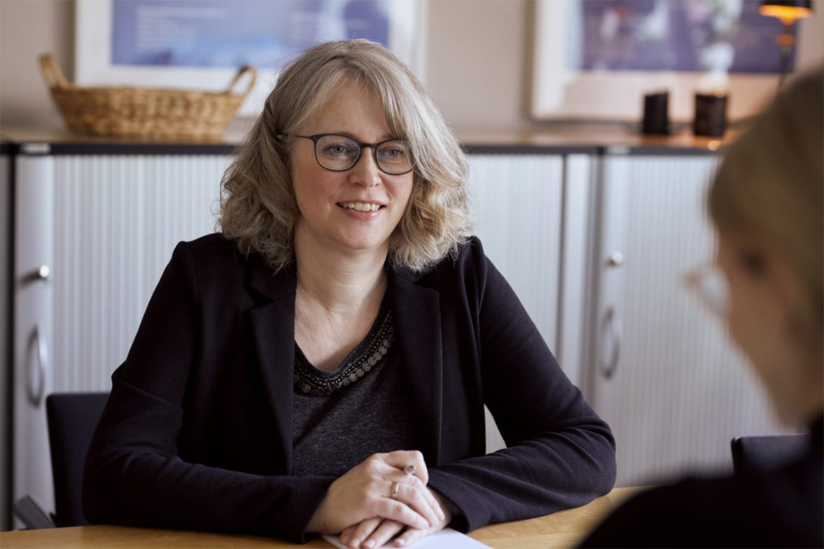 Foto: Christiane Schuster sitzt am Tisch