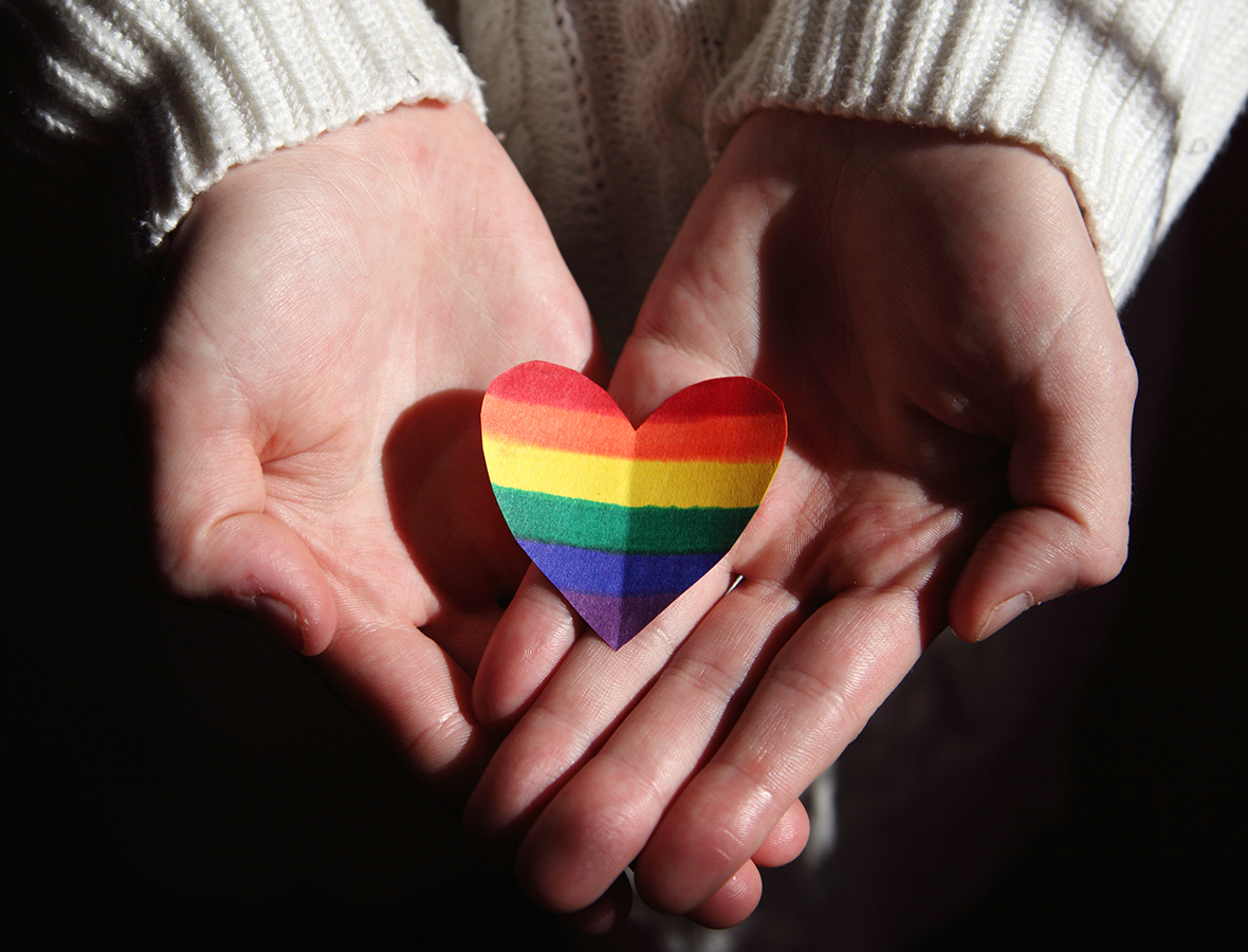 LSBTI*-Themenwoche: Auf zwei Händen liegt ein kleines Regenbogenherz