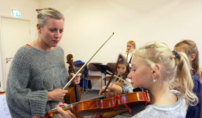 Karolin Broosch geht mit den jungen Musikerinnen den Ablauf durch.
