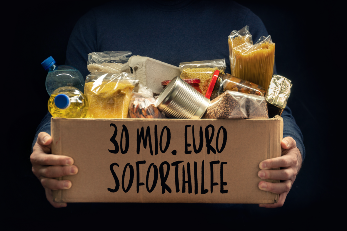 Lebensmittel in Karton mit Aufschrift "30 Mio. Euro Soforthilfe"